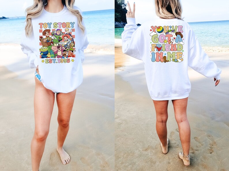 May include: White sweatshirt with a colorful graphic of Toy Story characters on the front and the text "Toy Story Est. 1995" and the text "You've Got a Friend in Me" on the back.