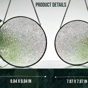 May include: Two circular, textured glass suncatchers with black metal frames and hanging chains. The larger one measures 25 x 25 cm, and the smaller one is 20 x 20 cm. The text "PRODUCT DETAILS" is visible at the top.