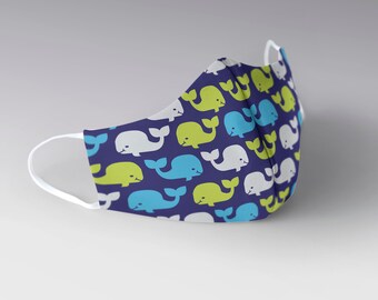 May include: A blue face mask with a repeating pattern of white, green, and blue whales.