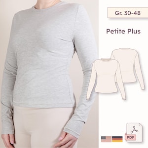 May include: A light gray long-sleeve shirt with a crew neck. The shirt is shown on a person and has a fitted silhouette. The image also includes a diagram of the shirt and text that reads "Gr. 30-48" and "Petite Plus".