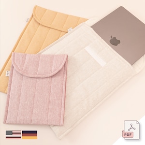 Könnte beinhalten: Eine Auswahl an gesteppten Laptop-Hüllen in verschiedenen Farben. Die Hüllen sind in Hellrosa, Beige und Gelb gehalten. Eine Hülle enthält einen Laptop mit Apple-Logo. Die Hüllen haben einen Klappenverschluss und vertikale Steppnähte.