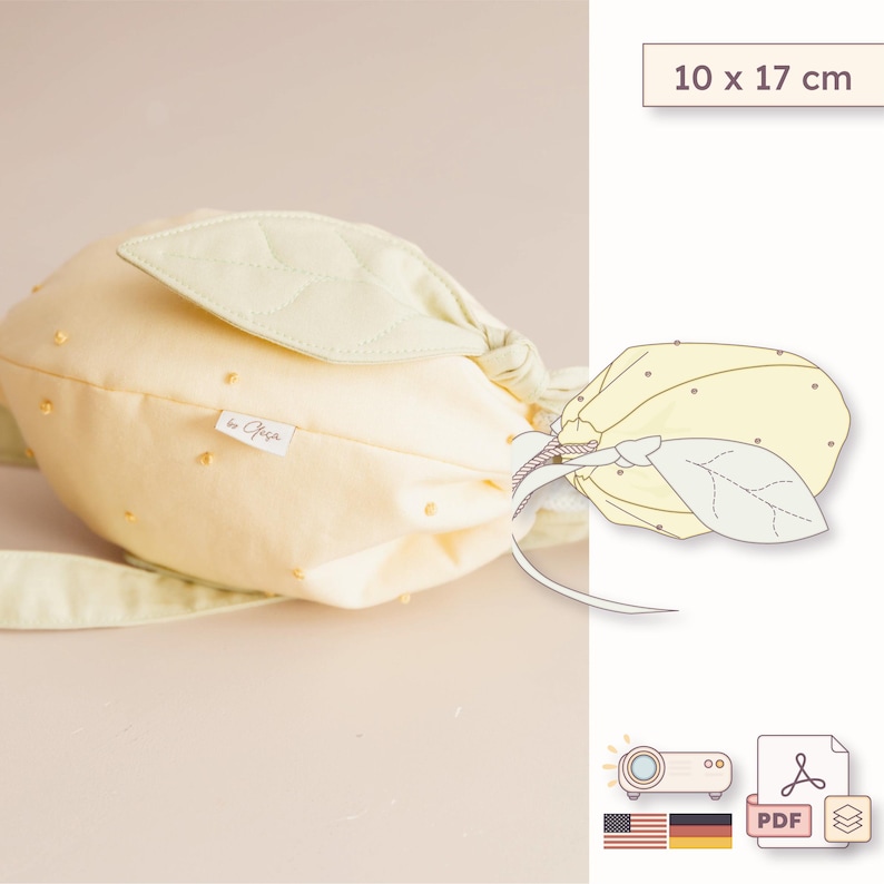 May include: A pale yellow fabric pouch shaped like a lemon, featuring a light green leaf accent, small yellow dot details, and a white brand tag. The pouch measures 10 x 17 cm. A line drawing of the lemon pouch is included in the image.