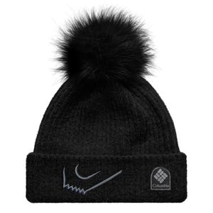 May include: Black knit beanie with a large black faux fur pom-pom. The hat features a gray embroidered design and the Columbia logo on the front. A warm winter accessory.