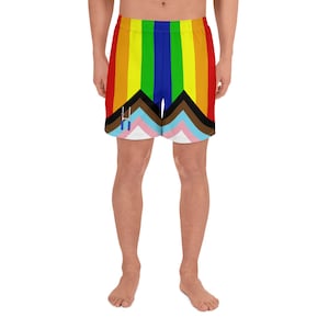 May include: A pair of athletic shorts with a rainbow and chevron pattern. The shorts have a black waistband and a drawstring.