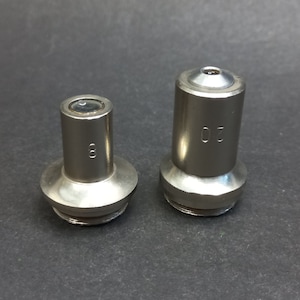 May include: Two silver microscope objectives, one labeled "8" and the other "20".