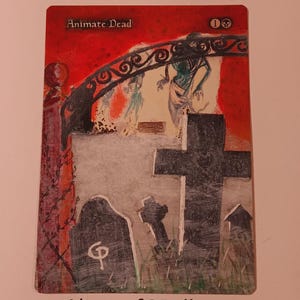 May include: A custom-painted card featuring the text "Animate Dead" and a mana symbol. The artwork shows a graveyard scene with tombstones, a gate, and spectral figures. The artist's name, "AltersofGPallone," is at the bottom.