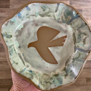Funky handcrafted pottery bowl, Soaring bird, Cream colored with blues and grays