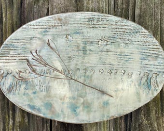 Plato de cerámica ovalado, esmaltes en tonos océano de ensueño, textura textil única.