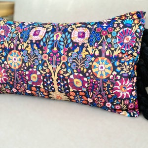May include: A black and multi-colored patterned throw pillow with black tassel trim.