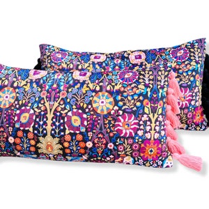 May include: Two decorative throw pillows with a colorful floral pattern and black and pink tassels. The pillows are made of a soft fabric and have a comfortable feel.
