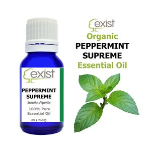 Puede incluir: Una botella de vidrio azul con una tapa blanca, etiquetada "Exist Organic Peppermint Supreme Essential Oil" y "Mentha Piperita 100% Pure Essential Oil". La botella está junto a una ramita de hojas de menta verde.
