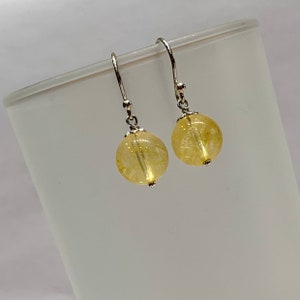 Peut inclure: Une paire de boucles d'oreilles pendantes en argent avec des perles de citrine jaune.