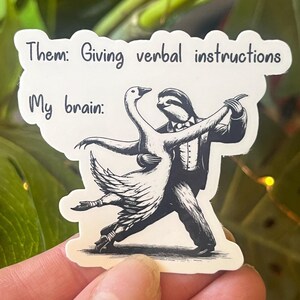 May include: A sticker with a black and white illustration of a sloth and a goose dancing. The text on the sticker reads "Them: Giving verbal instructions My brain:"
