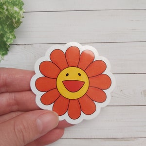 以下が含まれることがあります： 笑顔の顔が付いた赤と黄色の花のステッカー。花は白い輪郭で、白い背景になっています。