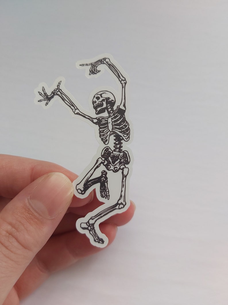 K&ouml;nnte beinhalten: Ein schwarz-wei&szlig;er Aufkleber eines tanzenden Skeletts. Das Skelett befindet sich in einer Sprungpose mit erhobenen Armen und gespreizten Beinen.