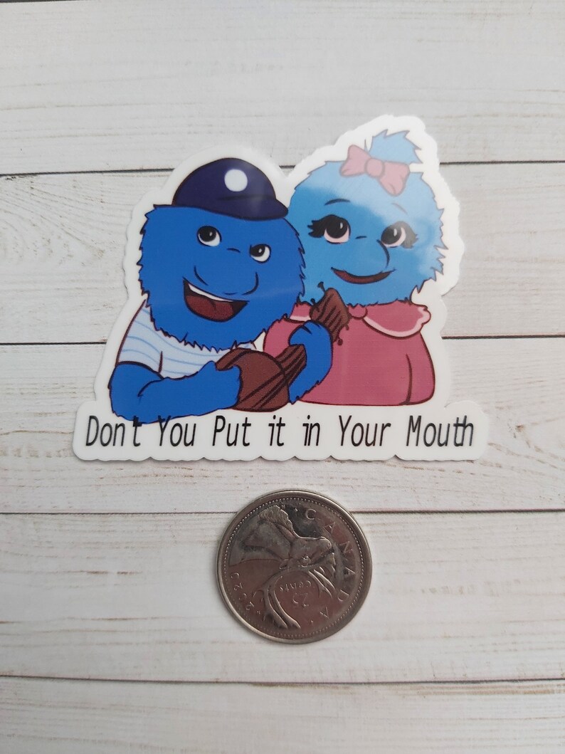 May include: A sticker featuring two blue fuzzy characters with big eyes and smiles. The characters are holding a brown guitar and the sticker says "Don't You Put it in Your Mouth".