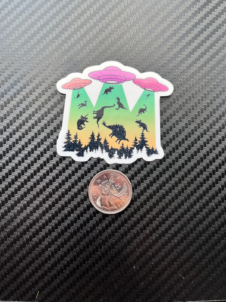 May include: A sticker featuring a group of dinosaurs being abducted by three flying saucers. The dinosaurs are silhouetted against a forest background with a gradient of green, yellow, orange, and red.