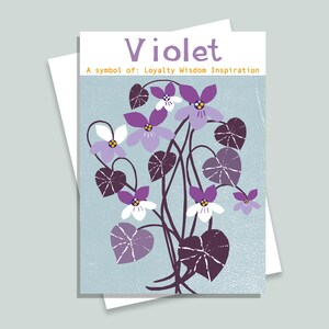 Może przedstawiać: Kartka okolicznościowa z ilustracją kwiatów fiołka. Karta ma jasnoniebieskie tło ze słowem "Violet" i tekstem "A symbol of: Loyalty Wisdom Inspiration". Kwiaty fiołka są fioletowe i białe.