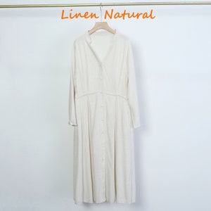 Puede incluir: Vestido largo de lino blanco roto con mangas largas y abotonadura frontal. El vestido tiene cuello mandar&iacute;n y cintura fruncida. El texto "Linen Natural" est&aacute; en naranja en la parte superior.