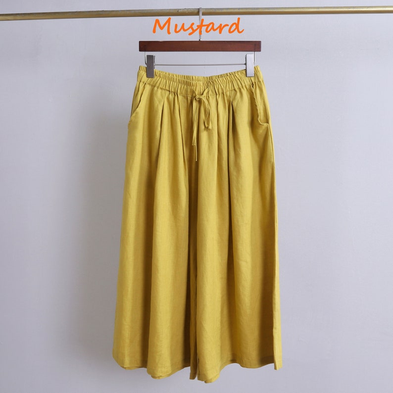 May include: Mustard yellow wide-leg pants with a drawstring waist and side pockets.