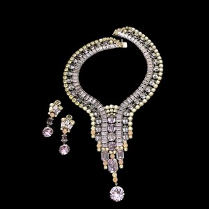 May include: A vintage rhinestone necklace and earrings set. The necklace features a cascading design with clear and pink rhinestones. The earrings are teardrop shaped with a single pink rhinestone.