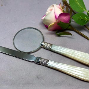 Antiguo juego de lupa y abrecartas de nácar con casquillo plateado. Ideal como regalo y accesorio de escritorio