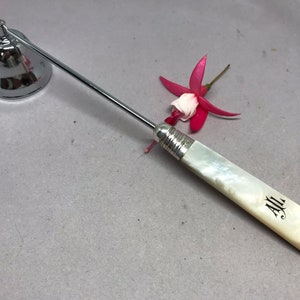 Stainless steel and mother of pearl Antique candle snuffer with monogram. Has a sterling silver ferrule. Ideal gift