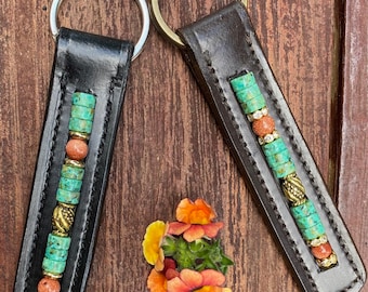 Llavero de cuero con cuentas de turquesa, piedra dorada y tono dorado.