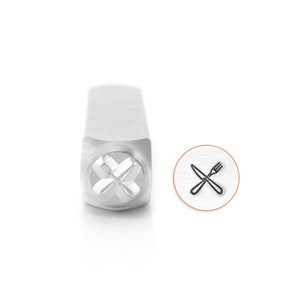 May include: A silver metal stamp with a design of a crossed fork and knife. The stamp is used for creating impressions in metal.
