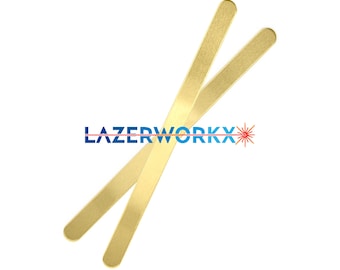 Può includere: Due bastoncini rettangolari color oro sono incrociati su uno sfondo bianco. I bastoncini hanno le estremità arrotondate. Il testo "LAZERWORKX" è stampato in blu, con un grafico a raggio laser rosso.