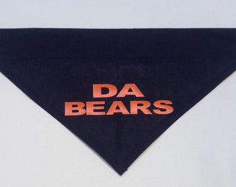 May include: A navy blue dog bandana with the text "DA BEARS" printed in orange.