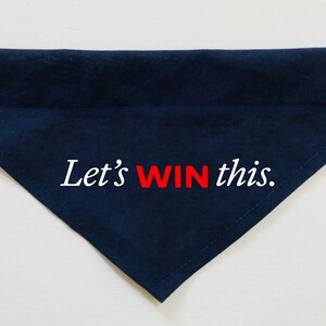 Puede incluir: Un bandana para perro azul marino con texto blanco que dice "Let's WIN this." La palabra "WIN" est&aacute; en rojo.