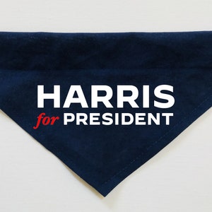 Puede incluir: Un bandana para perro de tela azul oscuro con texto blanco que dice "HARRIS for PRESIDENT" en rojo y blanco.