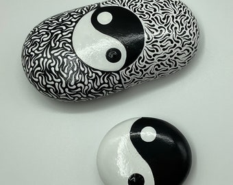 Presse-papiers yin et yang. Lot de 2 galets naturels peints à l’acrylique en noir et blanc avec symbole yin et yang. Décoration d’intérieur.