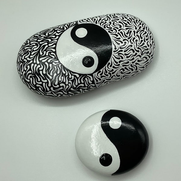 Presse-papiers yin et yang. Lot de 2 galets naturels peints à l’acrylique en noir et blanc avec symbole yin et yang. Décoration d’intérieur.