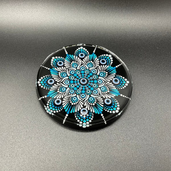 Dessous de verre à l’unité. Peinture de mandala à l’acrylique et incrustation de bijoux evil eye sur rondin de bois recouvert de résine.