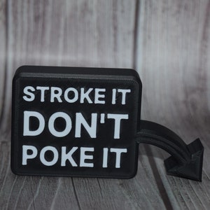 Puede incluir: Un letrero negro con texto blanco que dice "Stroke it Don't Poke it". El letrero tiene una flecha negra apuntando hacia la derecha.