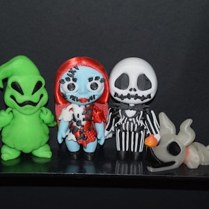 Puede incluir: Colección de figuras hechas a mano con personajes de "Pesadilla antes de Navidad". Incluye a Oogie Boogie en verde, Sally con pelo rojo y un vestido de retazos, Jack Skellington con traje a rayas y Zero.
