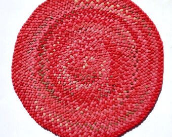 Braided rug, crafted by hand, wool fabric, round 31 inches, magenta, red, pink, orange.
