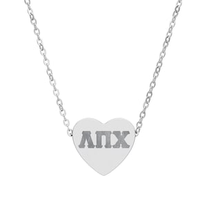 May include: A silver necklace with a heart-shaped pendant. The pendant displays the Greek letters ΑΠΧ. The chain is delicate and the pendant is centered, creating a simple and elegant design. The necklace is a stylish accessory.