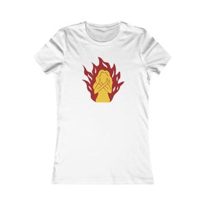 May include: White t-shirt with a yellow figure in crossed-arm pose, encircled by red flames. The design is on the front. The shirt has short sleeves and a crew neck. A casual wear item.