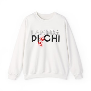 May include: A white crew neck sweatshirt featuring the text "LAMBDA PI CHI" in black, with red butterfly graphics. The sweatshirt is a casual style, suitable for everyday wear.