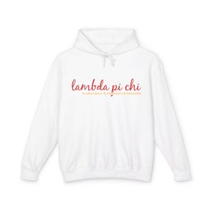 May include: A white hoodie featuring the red script text "lambda pi chi" on the front. Beneath this, in a smaller orange font, is the phrase "la cultura latina, la comunidad y la hermandad".