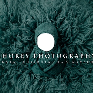 Puede incluir: Un conjunto de gorro y envoltorio para bebé de punto de color verde azulado sobre un fondo verde azulado difuso. El texto "SHORES PHOTOGRAPHY NEWBORN CHILDREN AND MATERNITY" es visible debajo del gorro y el envoltorio.