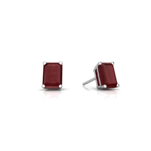 May include: A pair of silver stud earrings with red emerald-cut gemstones.