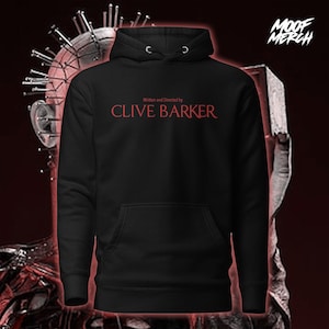 Peut inclure: Sweat à capuche noir avec l'inscription rouge "Written and Directed by CLIVE BARKER". Le sweat-shirt a une poche avant et une capuche à cordon. Le logo "MOOF MERCH" est dans le coin supérieur droit.
