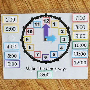 May include: A colorful clock face with movable hands. The clock face has numbers 1 through 12 in colorful squares. The hands are purple and blue. There are separate squares with the times 1:00 through 12:00. The text "Make the clock say: 3:00" is below the clock face.