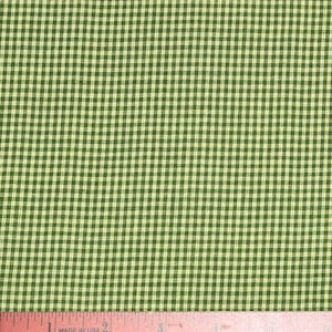 Puede incluir: Primer plano de tela de cuadros vichy verde y crema. La tela tiene un patrón de cuadros clásico, con pequeños cuadrados verdes y crema. Una regla rosa con el texto "MADE IN USA" está en la parte inferior.
