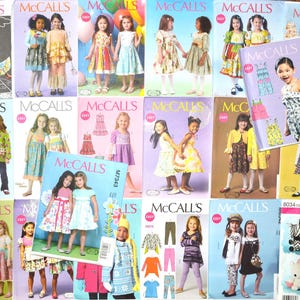 May include: A collection of McCall's and Simplicity sewing patterns for children's clothing, featuring various dress, top, and pant designs. Each paper envelope displays illustrations of children wearing the finished garments, with brand logos and pattern numbers.