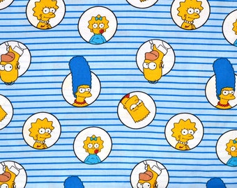 Peut inclure: Tissu à motifs avec des personnages de dessins animés dans des cercles blancs sur un fond à rayures bleues et blanches. Les personnages incluent une femme aux cheveux bleus, une fille avec un nœud et un garçon aux cheveux jaunes hérissés.